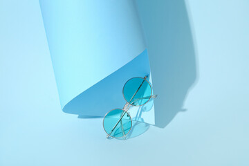 Stylish sunglasses on blue background