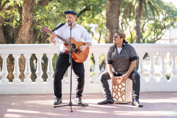 Street band performing at the street. Musicians palying guitar and flamenco box