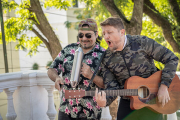 Street band performing at the street. Musicians palying guitar and güiro