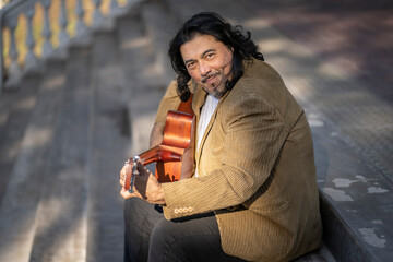 Flamenco guitarist sitting on some stairs performing