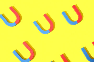 Horseshoe shaped magnets on yellow background