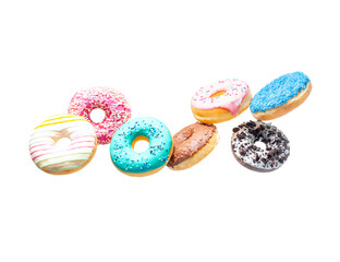Sweet donuts of different colors in flight on a white background