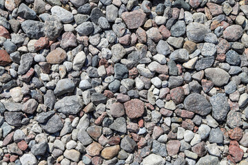 White, gray and pink stones on a cobble beach as a natural background