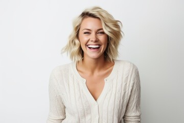 Fototapeta premium Portrait of a beautiful young woman laughing and looking at camera over white background