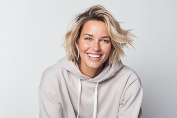 Obraz premium Portrait of a smiling woman in hoodie looking at camera over white background