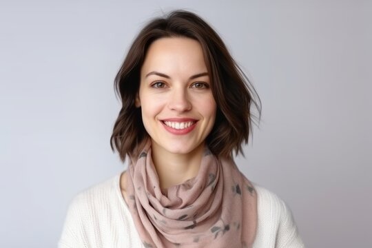 Medium shot portrait photography of a pleased woman in her 30s that is wearing a charming scarf against a white background . Generative AI