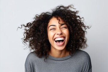 Portrait of a young african american woman laughing over white background