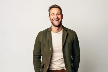 Portrait of a handsome young man laughing and looking at camera over white background