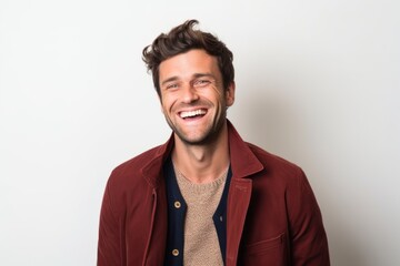 Fototapeta premium Portrait of a handsome young man laughing while standing against white background