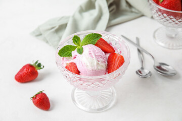 Glass bowl of strawberry ice cream on white table, closeup