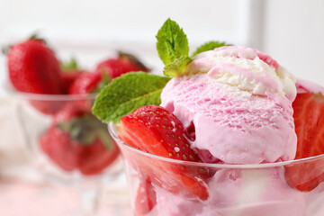 Glass of strawberry ice cream with mint on table, closeup