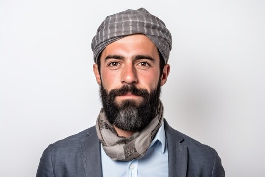 Handsome bearded man wearing a hat and scarf on white background