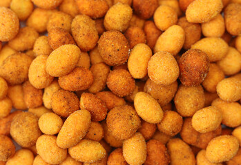 Spicy sauce coated peanuts backdrop pattern background. Hot paprika snack appetizer