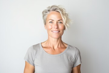Portrait of beautiful middle aged woman smiling at camera against white background