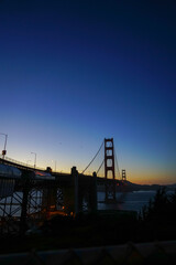Fototapeta na wymiar View of the sun setting behind the Golden Gate Bridge in San Francisco, California