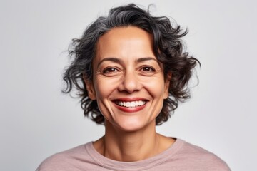 Close up portrait of a beautiful middle aged woman smiling and looking at the camera over white background