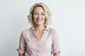 Obraz premium Portrait of happy mature businesswoman smiling at camera while standing against white background