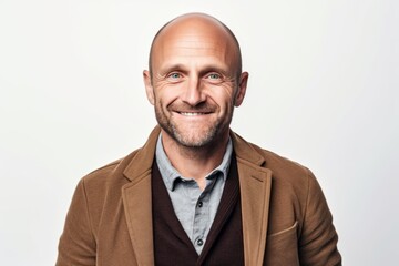 Portrait of a handsome bald man wearing a brown jacket and smiling at the camera.