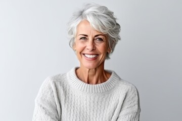 Portrait of senior woman with grey hair smiling at camera, isolated over white background