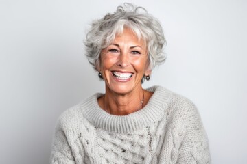 Portrait of a happy senior woman smiling at the camera over gray background