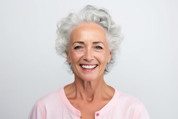 Fototapeta na wymiar Portrait of a smiling senior woman looking at camera over white background