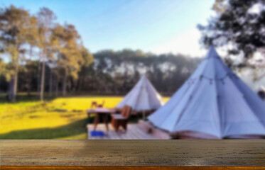 Wooden table top on blur tent camping travel tent and grass field.Fresh and Relax concept.For...
