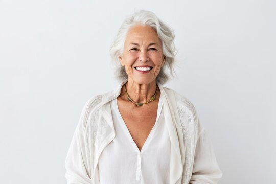 Medium shot portrait photography of a grinning woman in her 60s that is wearing a chic cardigan against a white background . Generative AI