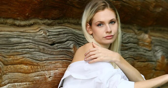 young beautiful blonde model posing against the background of a wooden wall