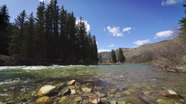 Low wide angle of Mountain river on sunny day flowing down stream