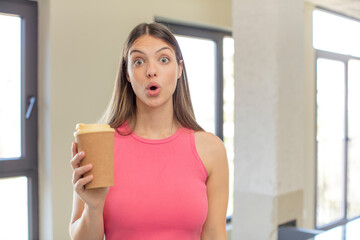 Fototapeta na wymiar young pretty woman feeling extremely shocked and surprised. take away coffee concept