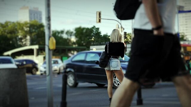Attractive girl in shorts taking photo in the street
