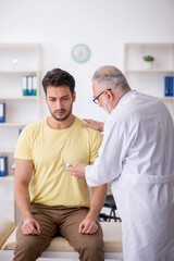 Obraz premium Young male patient visiting old male doctor