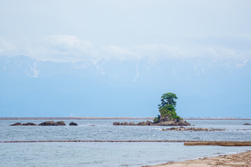 海に大きな岩が浮かんでいる景色 高岡雨晴海岸 A view of a large rock floating in...