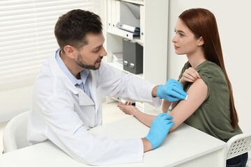 Obraz premium Doctor giving hepatitis vaccine to patient in clinic