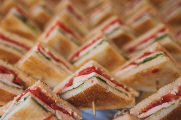 Catering table, beautifully decorated banquet table with variety of different food snacks, sandwiches, croissants and appetizers on a party event or celebration, delicatessen setting, coffee break