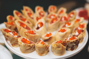 Catering table, beautifully decorated banquet with variety of with different food snacks appetizers on corporate birthday party event or wedding celebration, canape, salad, delicatessen setting