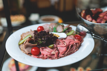 Catering table, beautifully decorated banquet with variety of with different food snacks appetizers on corporate birthday party event or wedding celebration, canape, salad, delicatessen setting