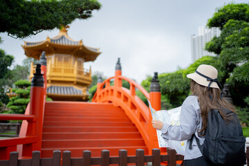 Asian tourist, cute woman with long hair are traveling in Hong Kong along with map and her camera...