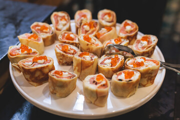 Catering table, beautifully decorated banquet with variety of with different food snacks appetizers on corporate birthday party event or wedding celebration, canape, salad, delicatessen setting