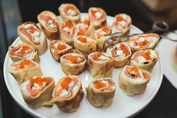 Catering table, beautifully decorated banquet with variety of with different food snacks appetizers on corporate birthday party event or wedding celebration, canape, salad, delicatessen setting