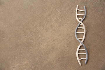 DNA molecule model made of colorful plasticine on brown background, top view. Space for text