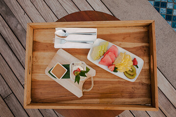 Fresh Fruit on wooden board and wooden table at swimming pool area. Summer concept for fruit