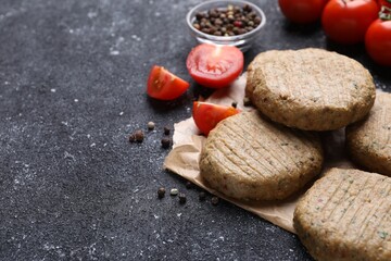 Tasty vegan cutlets and products on grey table, closeup. Space for text