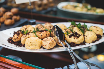 Beautiful multicolored decorated baked sweet tasty candy bar dessert on kids children party with happy people around, catering banquet table on kids children party