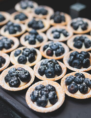 Beautiful multicolored decorated baked sweet tasty candy bar dessert on kids children party with happy people around, catering banquet table on kids children party