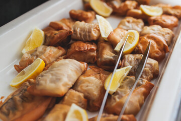 Beautifully decorated catering banquet table with different main course hot food dishes and garnish, with a rice, chicken, salmon fish, lamb, vegetables and kebab on party event wedding celebration