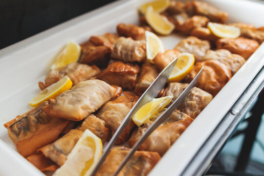 Beautifully decorated catering banquet table with different main course hot food dishes and garnish, with a rice, chicken, salmon fish, lamb, vegetables and kebab on party event wedding celebration