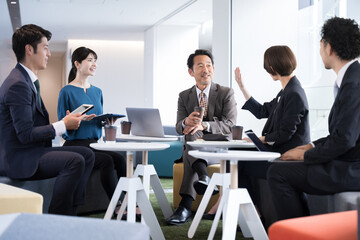 きれいなオフィスビルの会社で社長や責任者が部下と話す様子のビジネスシーン　コピースペースあり