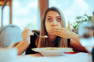 
Woman Eating Soup in a Restaurant Feeling Sick
Sick girl feeling unwell after eating contaminated food 
