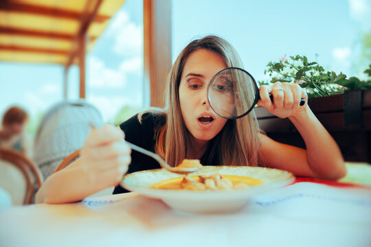 Picky Eater Inspecting Soup with Magnifying Glass. Perfectionist woman checking her meal for any wrong details
